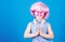 Calm and cute. Cute child clasping hands together. Cute little girl wearing pink wig and fancy glasses with praying