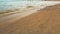 Calm day at Ein Bokek Dead Sea beach, blue green water, sun shade shelter near, sun shines on sandy beach shore