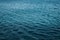 Calm deep blue sea with ripples on the surface of the water. Dark blue background and texture