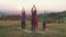 Calm diverse multiethnic sporty fit people practicing group yoga class on mountain top at sunrise