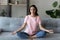 Calm ethnic woman practice yoga at home