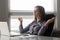 Calm female office employee meditating at workplace