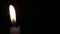 A calm flame of a blue candle on a black background A convenient place for text