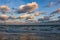 Calm foamy waves of the sea hitting the shore under the blue sky in Cotentin Peninsula