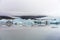 Calm foggy morning at Fjallsarlon glacier lagoon at the end of Vatnajokull glacier in Iceland. Icebergs reflects in the calm water