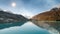 Calm Gokyo Lakes reflect bright sunlight and rocky hills