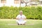 Calm of Healthy Asian Elderly man with white hairs doing yoga lotus pose for meditation on green grass at park,Wellness Senior