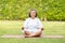 Calm of Healthy Asian Elderly woman with white hairs doing yoga lotus pose for meditation on green grass at park,Wellness Senior