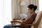 Calm indian female relax in chair use notebook at home