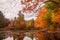 A calm lake in the forest with brightly colored autumn trees and reflections in the water.