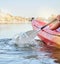 Calm lake, water sport and woman on kayak adventure for summer travel trip canoeing, kayaking and using paddle on river