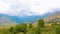 Calm landscape with green valley, mountains and clouds on sky, timelapse