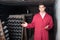 Calm man wearing uniform working with bottle storage racks