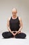 Calm middle-aged man exercising yoga in studio