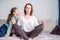 Calm mindful single mom doing yoga at home while active noisy kid daughter screaming in her ear, mother meditating for stress