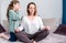 Calm mindful single mom doing yoga at home while active noisy kid daughter screaming in her ear, mother meditating for stress