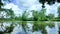 A calm nature pond view with reflection and clouds