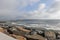 Calm ocean inlet with boulder jetty as dark storm clouds approach