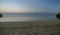 Calm ocean water scene in early morning sunrise with Rinjani volcano in distance shot in Sumbawa island, NTB, Indonesia