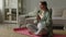 Calm pregnant woman deep breathing doing yoga in lotus pose comfortable at home.