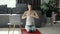 Calm pregnant woman doing yoga online at home in lotus pose