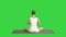 Calm pretty woman doing yoga exercise sitting in yoga pose on a green screen, chroma key.