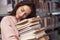 Calm and quiet. Brunette girl in casual clothes having good time in the library full of books