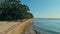 Calm and relaxing aerial drone image of a stunning beautiful hidden remote ocean sea shore at sunset with an endless sandy beach