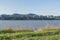 A calm river and and two fishing rods and green grass and blue sky at Hangang Park, Seoul, South Korea