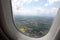 Calm rural European landscape view till skyline with clouds from the flying airplane window on bright sunny summer day