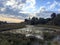 Calm rustic landscape with river, church and clouds on the sky in sunset