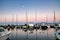 Calm scene of boats in Lahaina boat harbor early morning with setting moon.