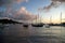 Calm sea with lots of boats sailing on it around tropical islands under a bright sky full of clouds