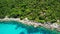 Calm sea near tropical volcanic island. Drone view of peaceful water of blue sea near stony shore and green jungle of volcanic Koh