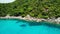 Calm sea near tropical volcanic island. Drone view of peaceful water of blue sea near stony shore and green jungle of volcanic Koh