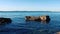 Calm sea waves moving around a rock on the shore of the adriatic sea.