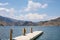 Calm serene dock at a blue lake surrounded by mountains