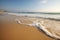 calm and serene golden beach, with waves rolling gently onto shore