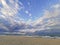 Calm and serene quiet sandy beach in the tranquil afternoon near the sea. There are unidentified people on the beach