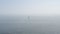 Calm serene sea disappears behind horizon. Surfer girl floating on surfboard