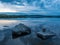 Calm, serenity, meditation concept. Sunset on the lake, stones in the water in the foreground, quiet water, cloudless sky