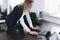 Calm serious young attractive blonde woman uses laptop to work at table in office