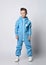 Calm, smart kid boy in blue jumpsuit with zipper and reflective stripes stands looking aside at copy space