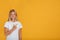 Calm smart smiling caucasian teenage girl pupil in white t-shirt points her finger towards empty space