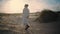 Calm tourist walking dunes beach in morning sunlight. Serene model contemplating