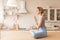 Calm and tranquil short-haired woman sitting in lotus posture on kitchen table