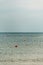 Calm water surface on which orange buoys fly