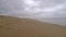Calm waves coming towards the camera view in a lonely beach during a cloudy day