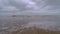 Calm waves coming towards the camera view in a lonely beach during a cloudy day