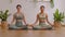Calm of wellness Couple Asian young woman sit on yoga mat doing breathing exercise yoga lotus pose together.Yoga meditation of two